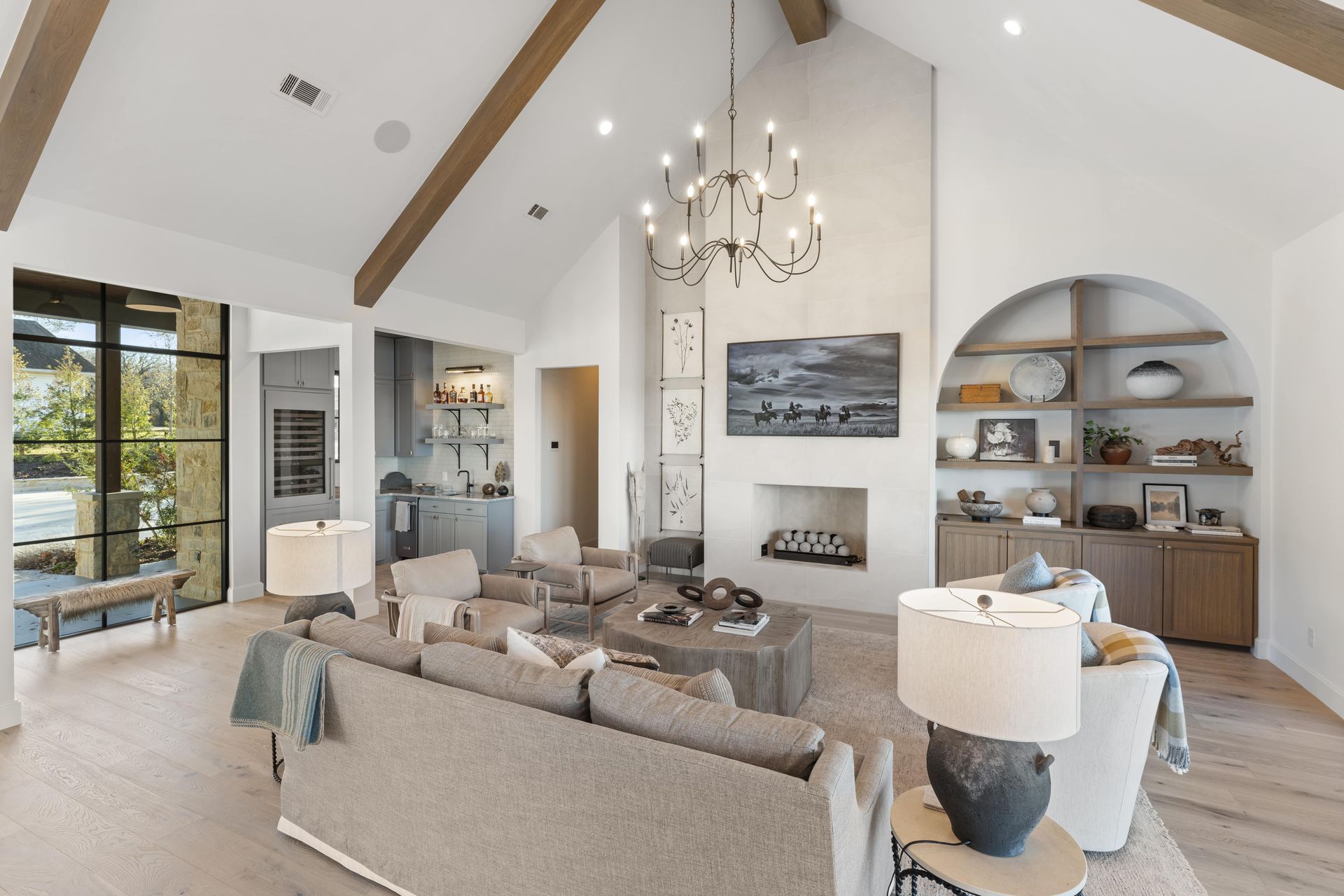 A living room with a couch , chairs , lamps and a fireplace.