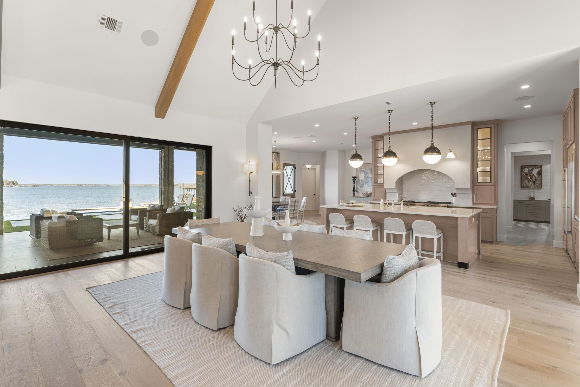 A dining room with a table and chairs and a view of the ocean.