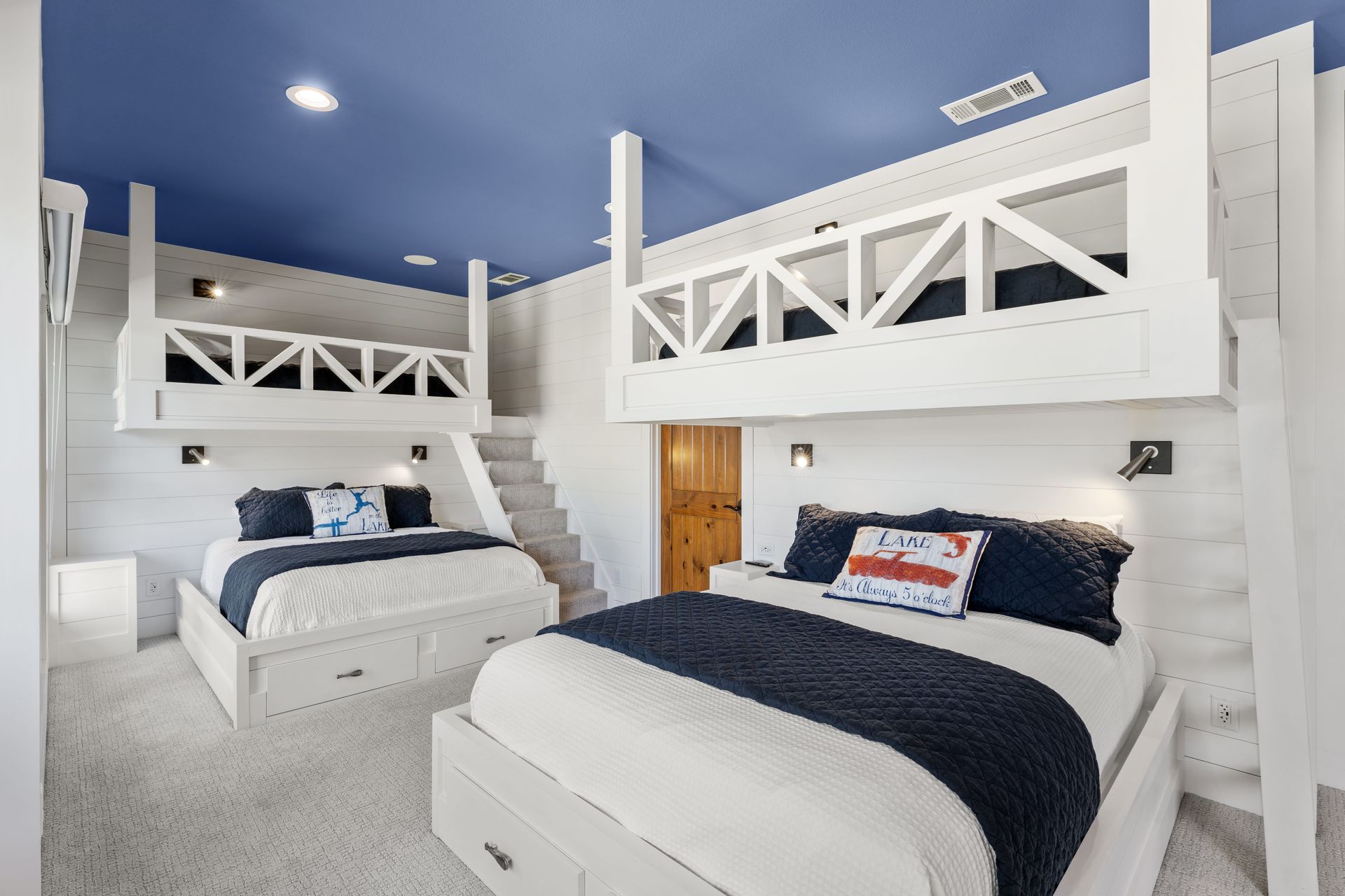 A bedroom with two bunk beds and a blue ceiling.