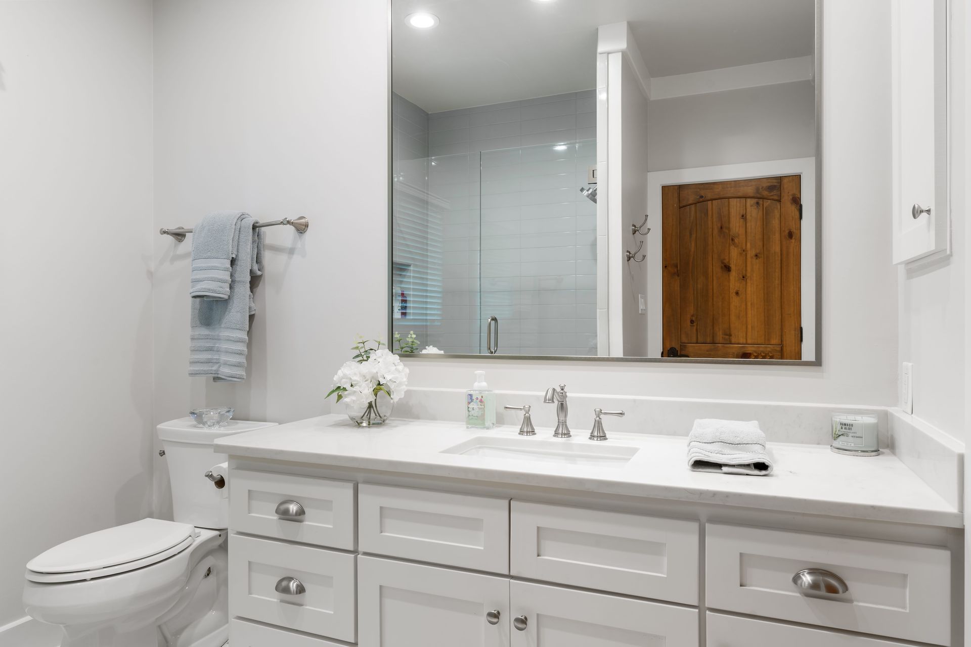 A bathroom with a toilet , sink , and mirror.