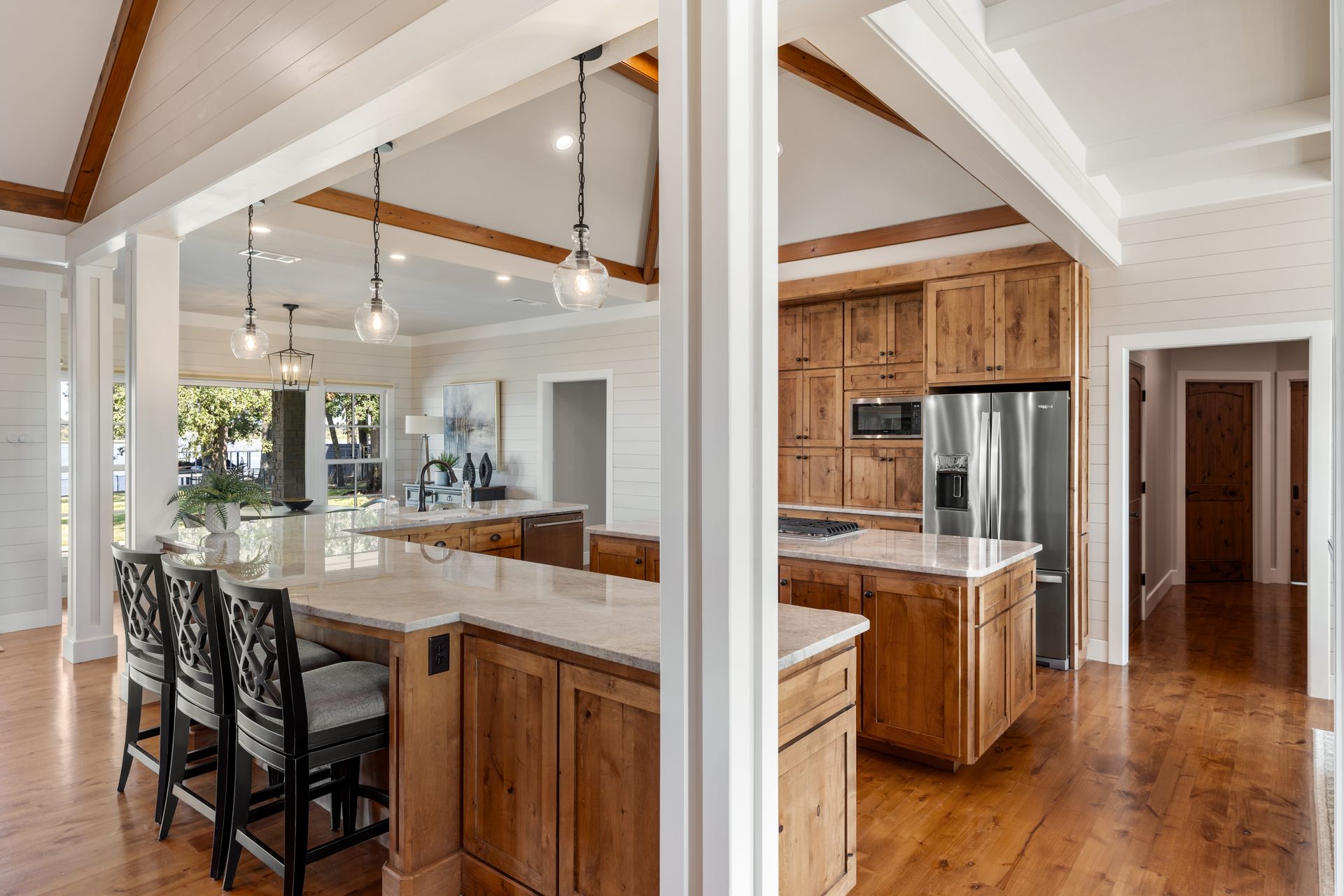A kitchen with wooden cabinets , granite counter tops , and stainless steel appliances.