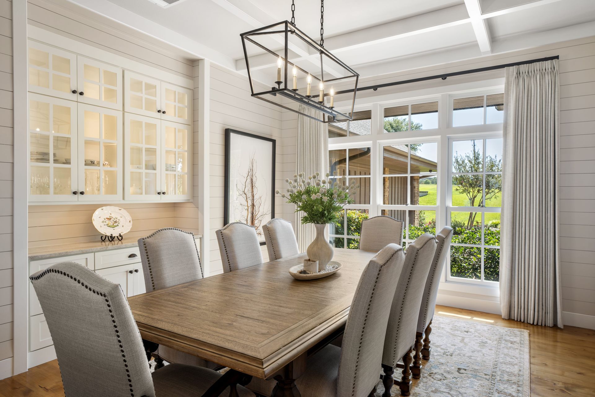 A dining room with a long table and chairs and a chandelier.