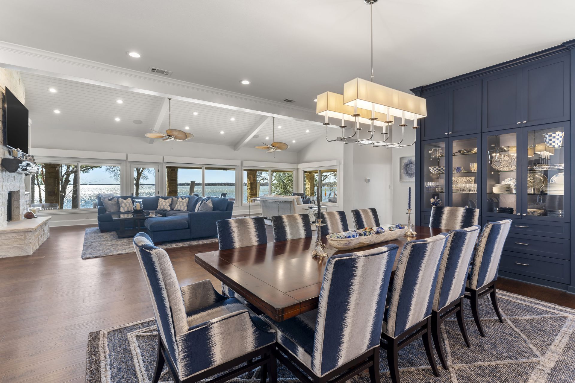 A dining room table and chairs in a large house with a view of the ocean.