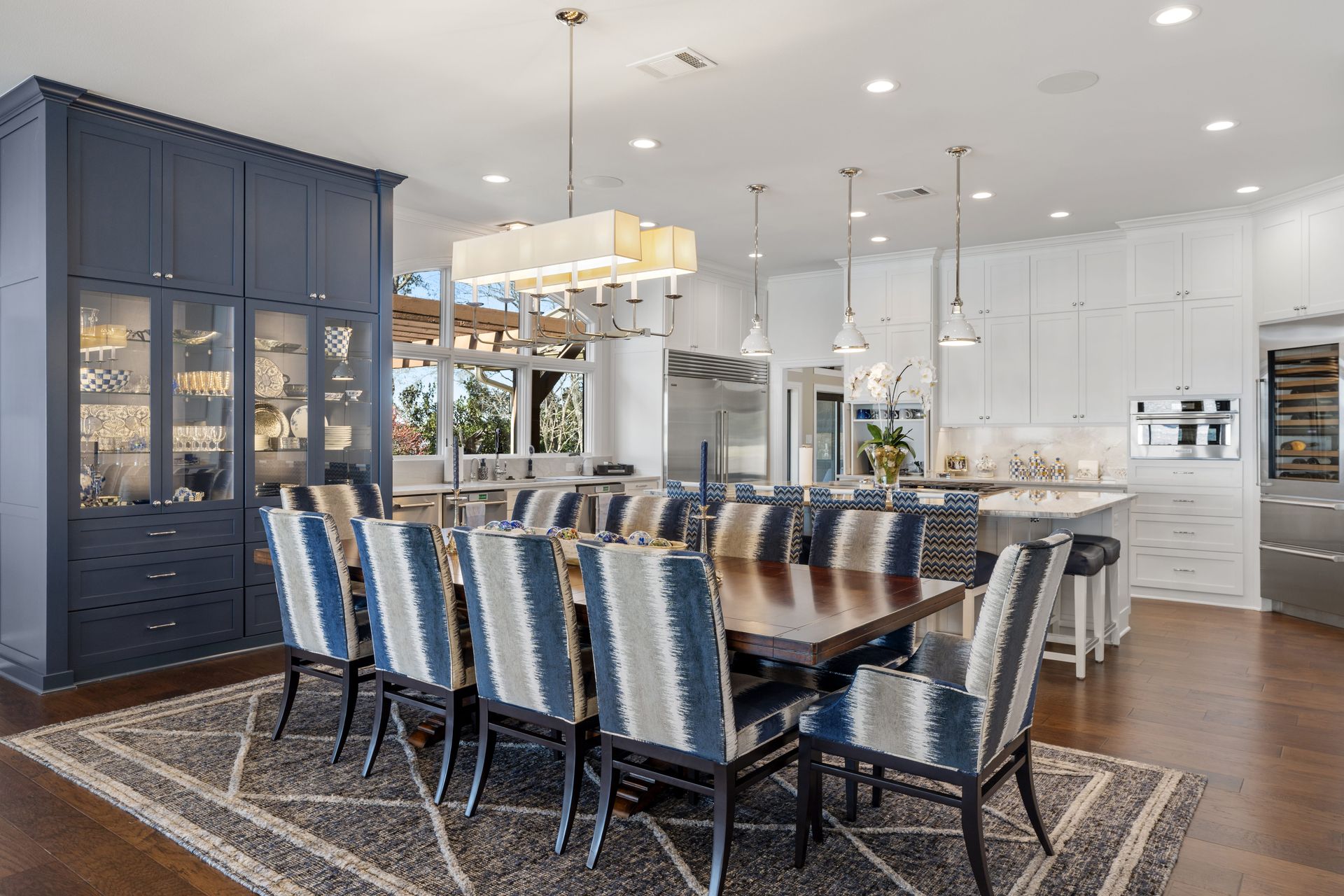 A dining room with a table and chairs and a rug.