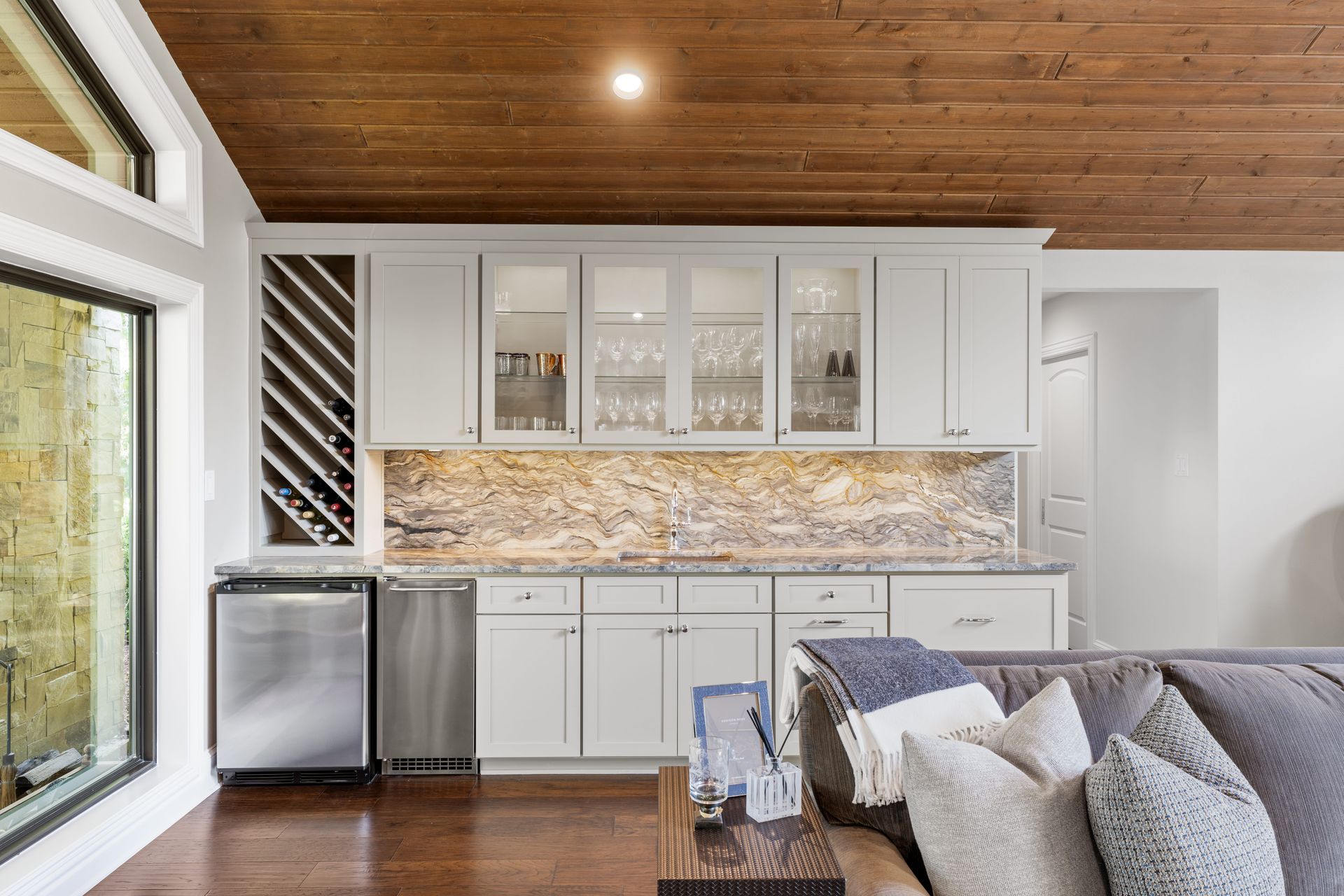 A living room with white cabinets and a wooden ceiling.