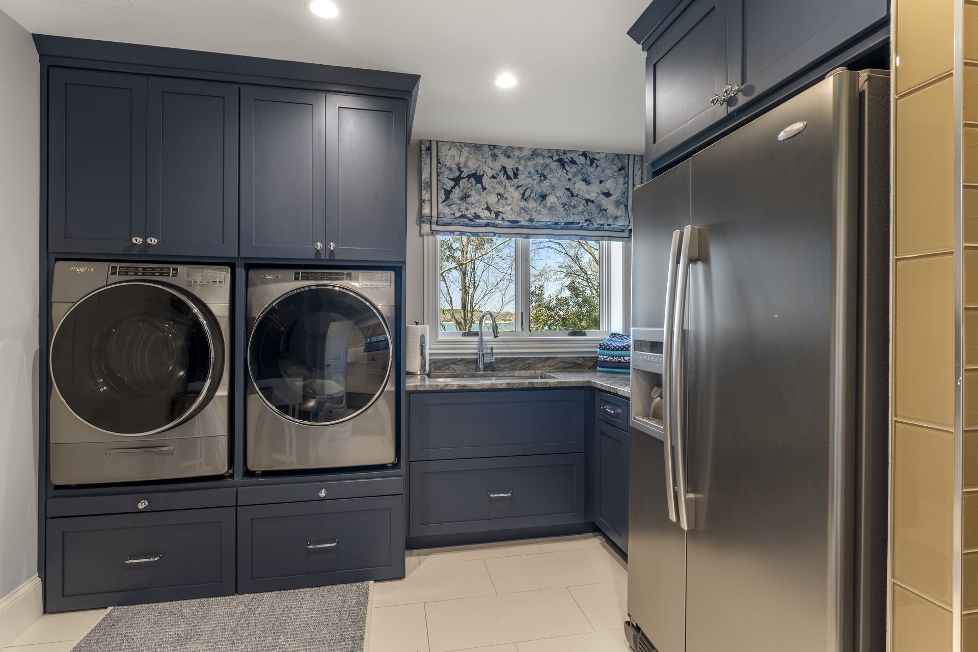 A laundry room with a washer and dryer and a refrigerator.