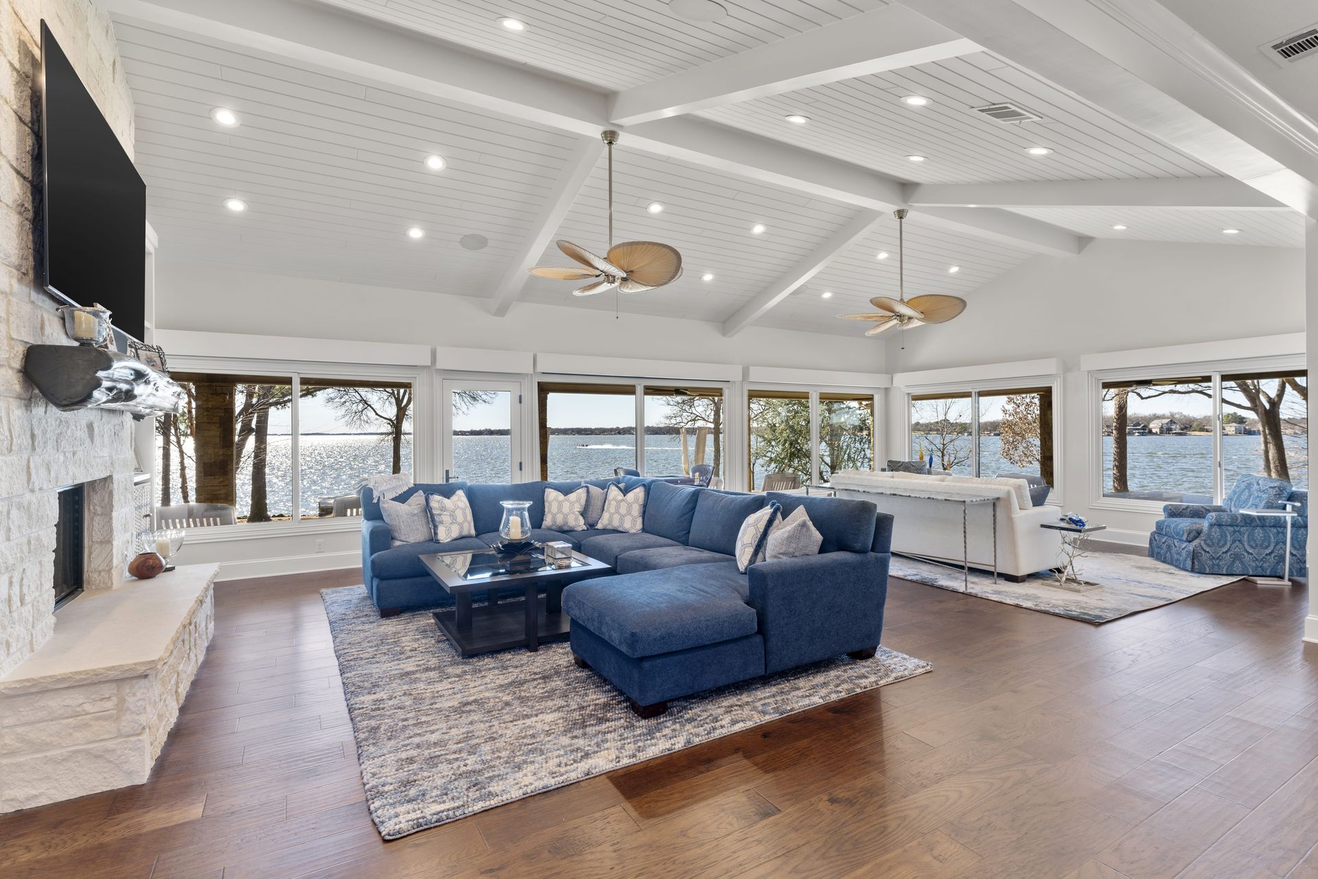 A living room with a blue sectional couch and a fireplace.
