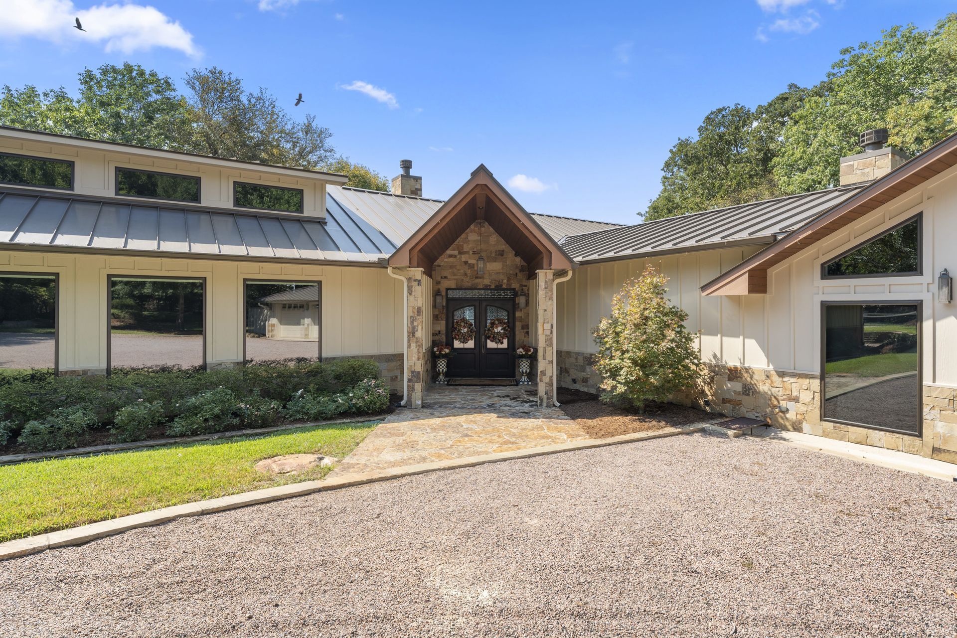 A large house with a gravel driveway leading to it