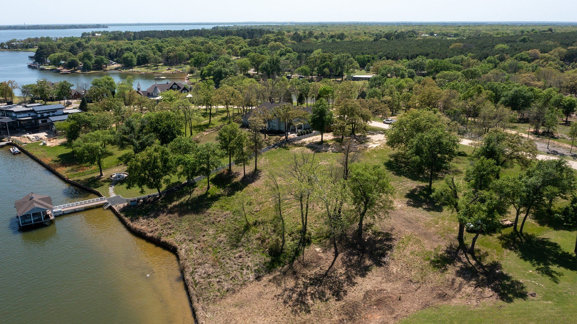 An aerial view of a lake surrounded by trees and grass.