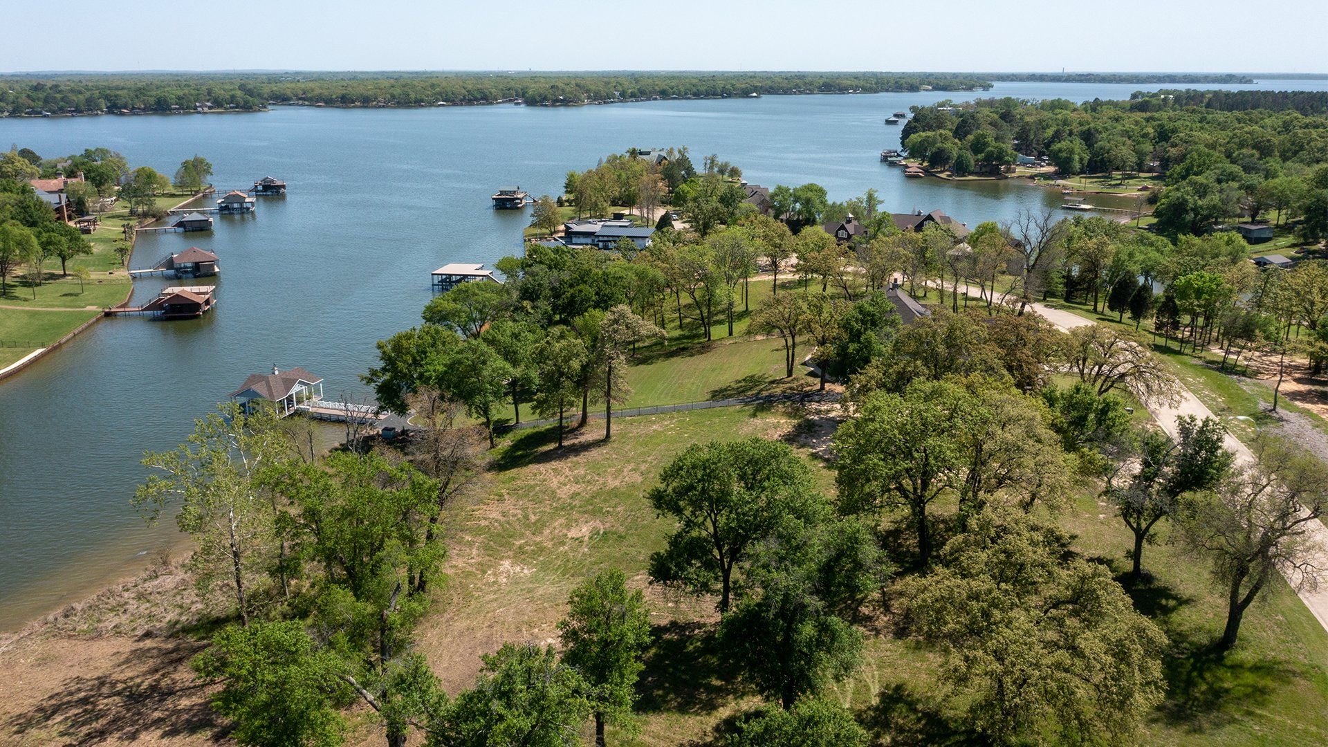 An aerial view of a lake surrounded by trees and houses