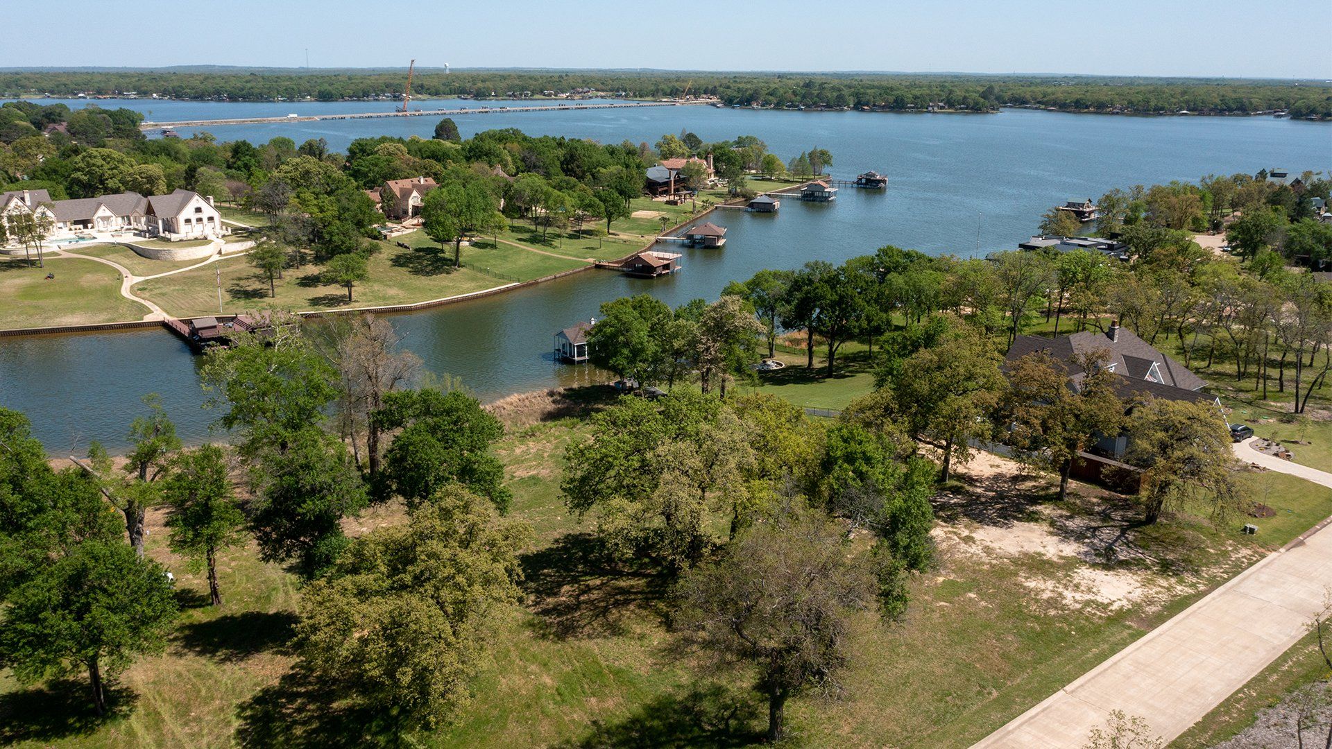 An aerial view of a lake surrounded by trees and houses.