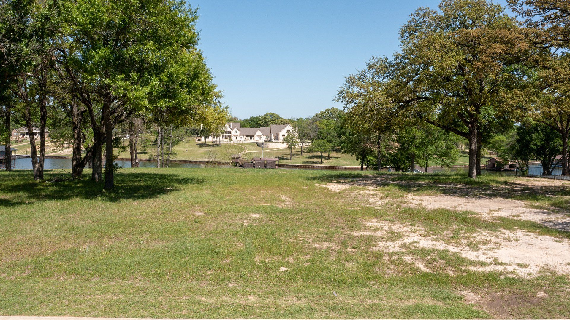A grassy field with trees and a house in the background