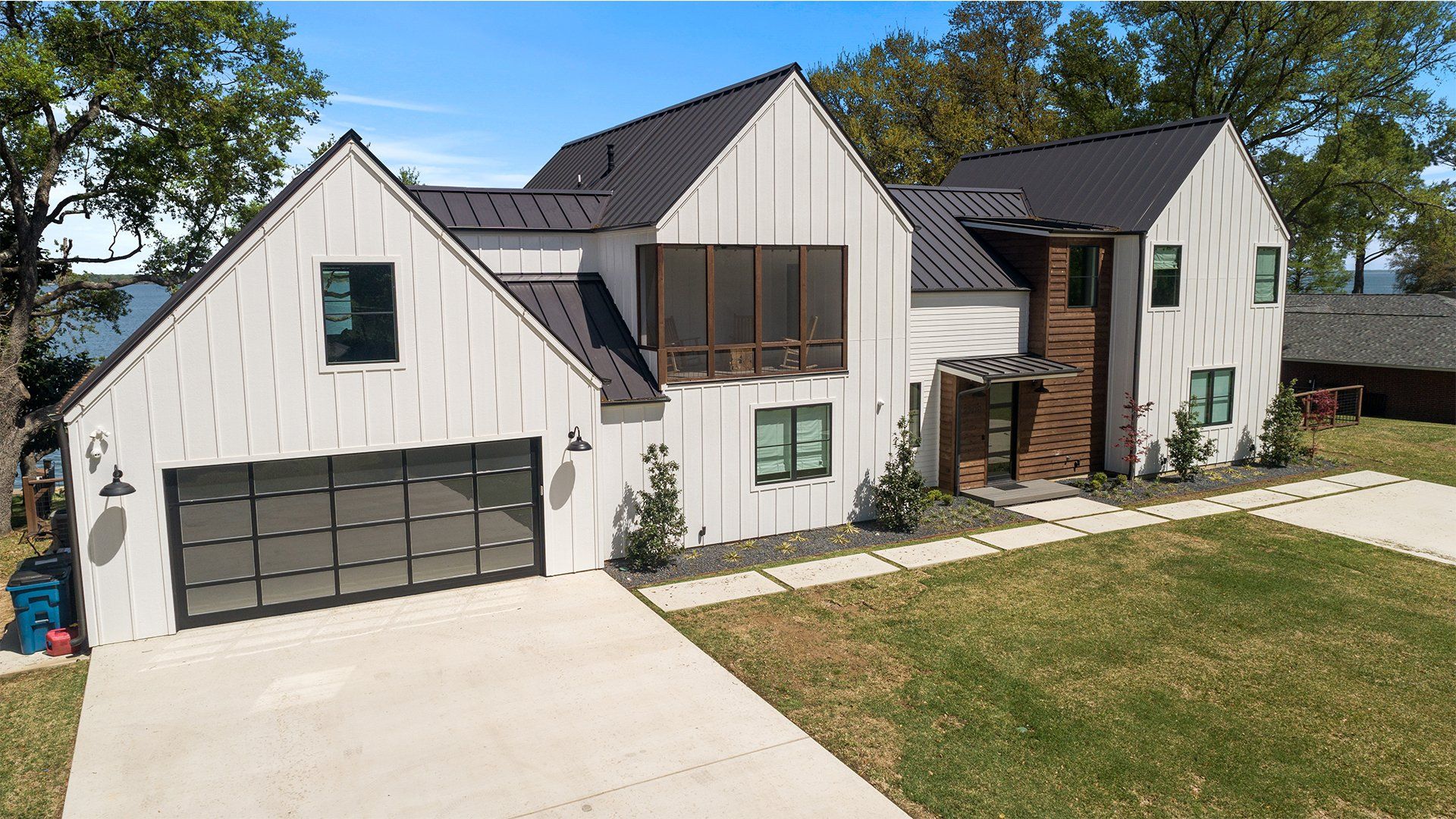 An aerial view of a large white house with a black roof.