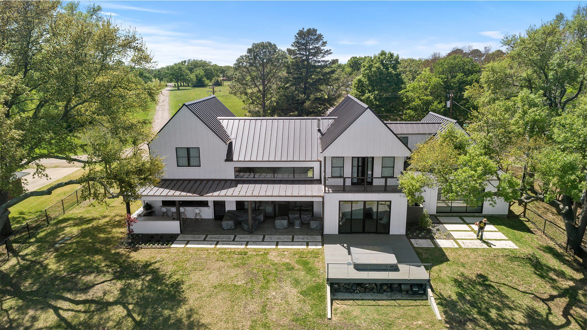 An aerial view of a large white house surrounded by trees.
