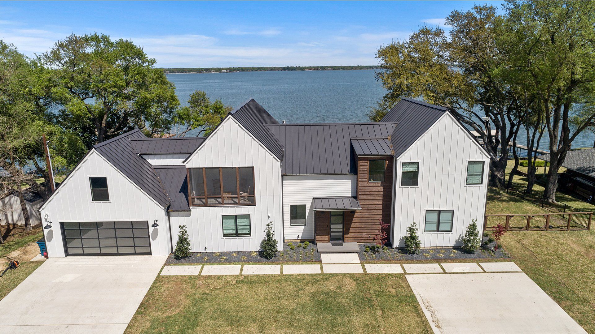 An aerial view of a large white house next to a body of water.