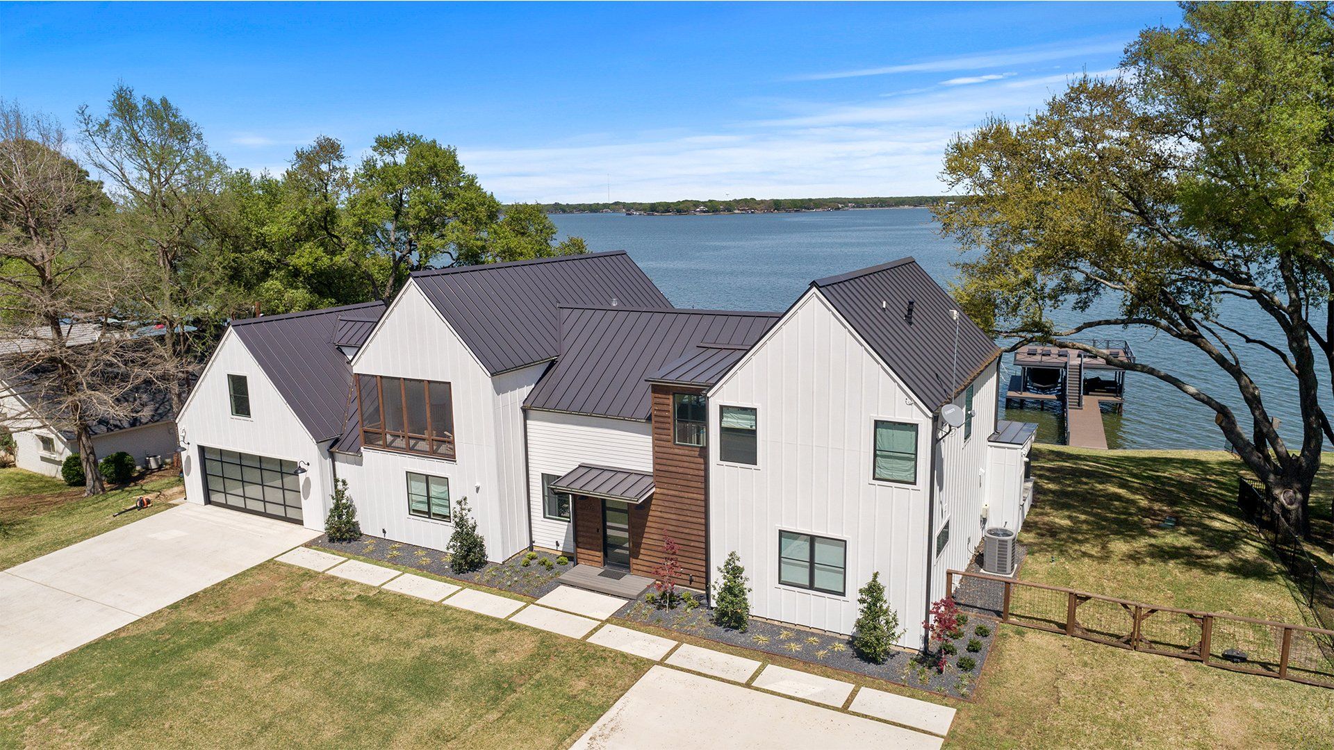 An aerial view of a large white house next to a body of water.