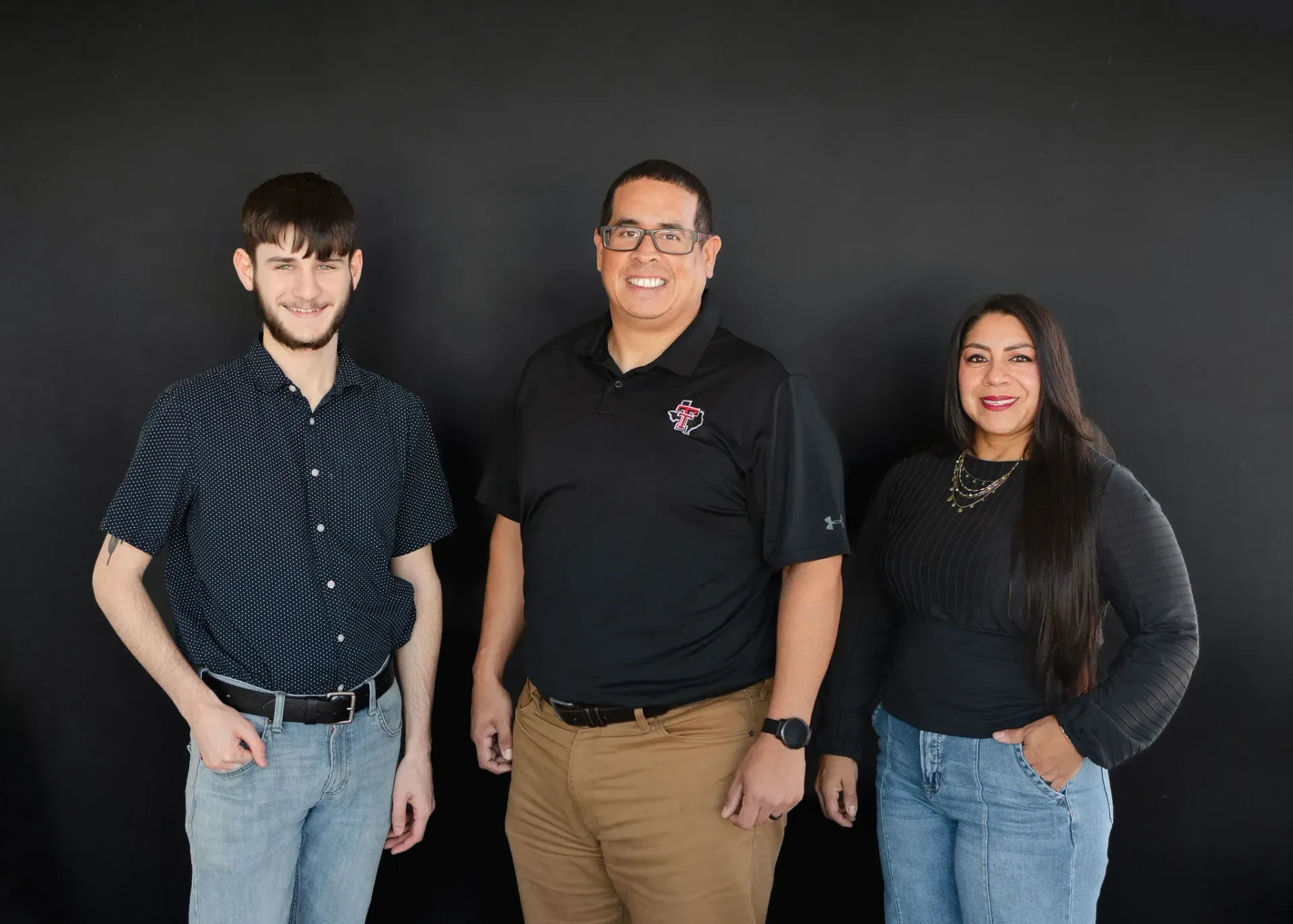 LSM Insurance Agency members stand in front of a black wall.