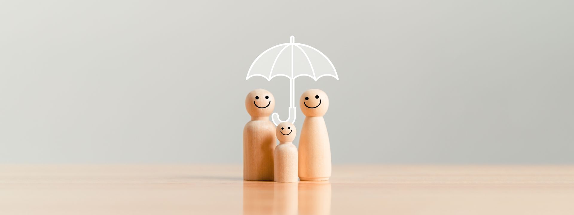 Three wooden figures stand together under a drawn white umbrella outline against a plain light gray background.
