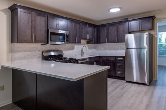 A kitchen with stainless steel appliances and wooden cabinets.