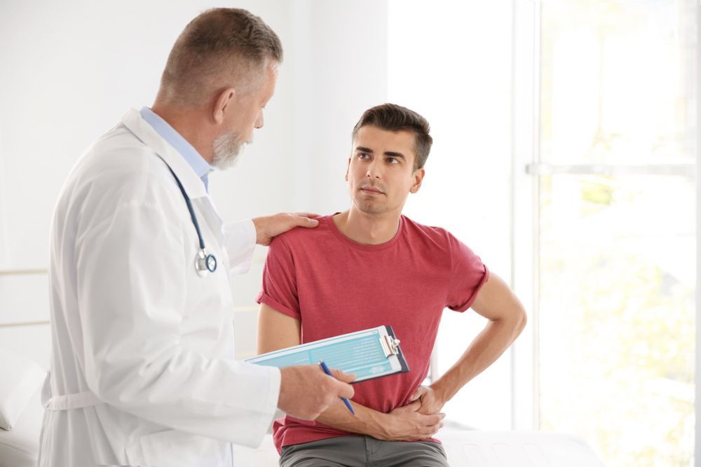 A Doctor is Talking to a Patient Who is Sitting on a Bed — Mount Archer Medical Centre in Berserker, QLD