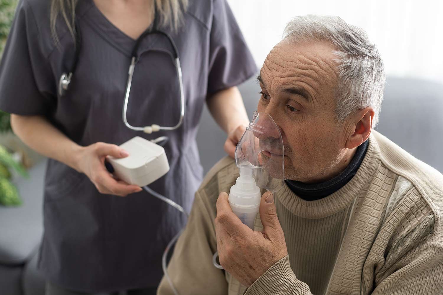 An Elderly Man is Getting an Oxygen Mask From a Nurse — Mount Archer Medical Centre in Berserker, QLD