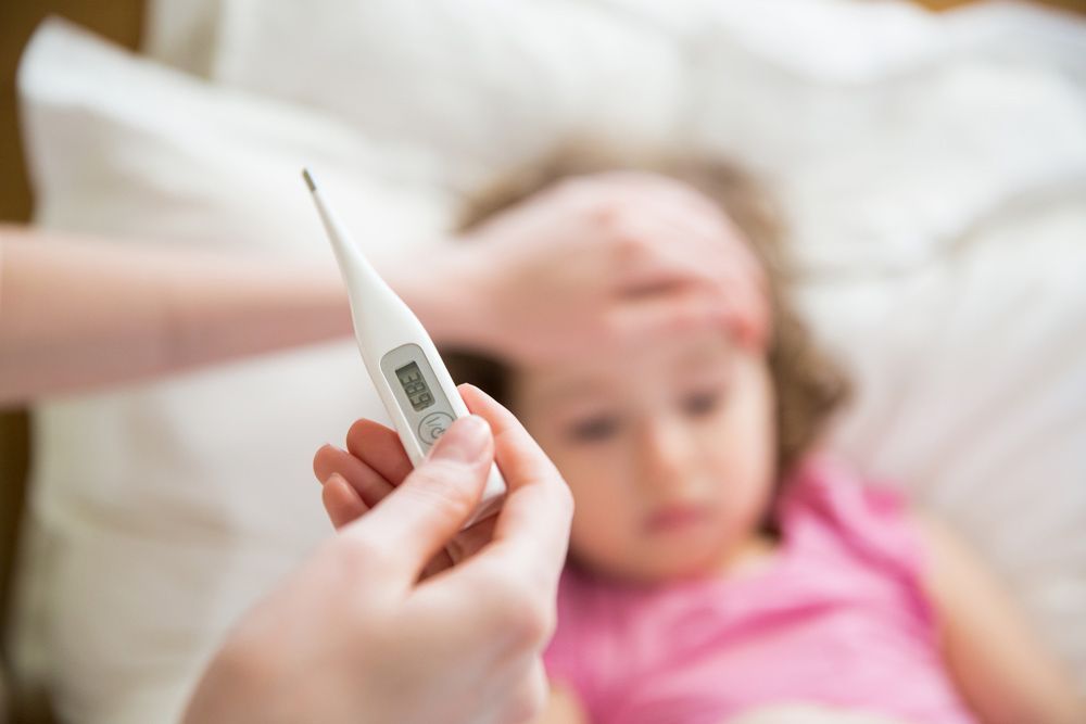 A Person is Taking a Child's Temperature With a Thermometer — Mount Archer Medical Centre in Berserker, QLD