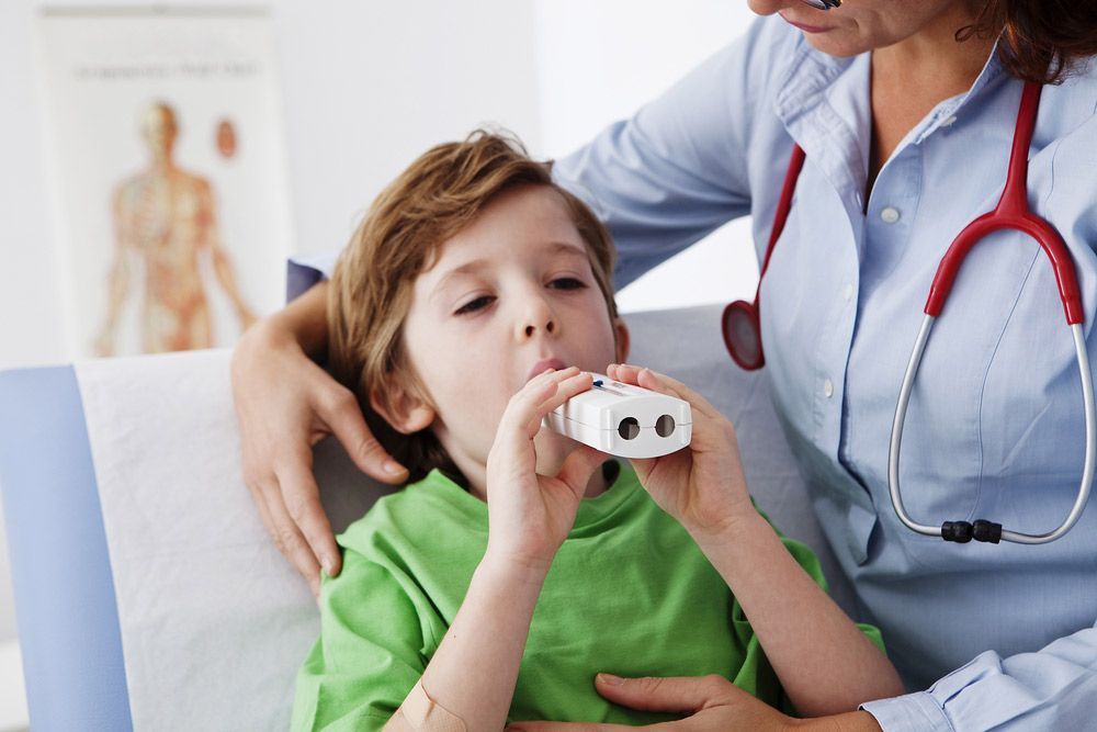 A Young Boy is Being Examined by a Doctor While Using an Inhaler — Mount Archer Medical Centre in Berserker, QLD