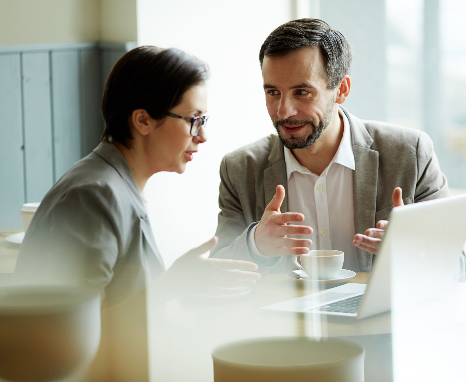 A man with a backpack is standing next to a lake in the woods.