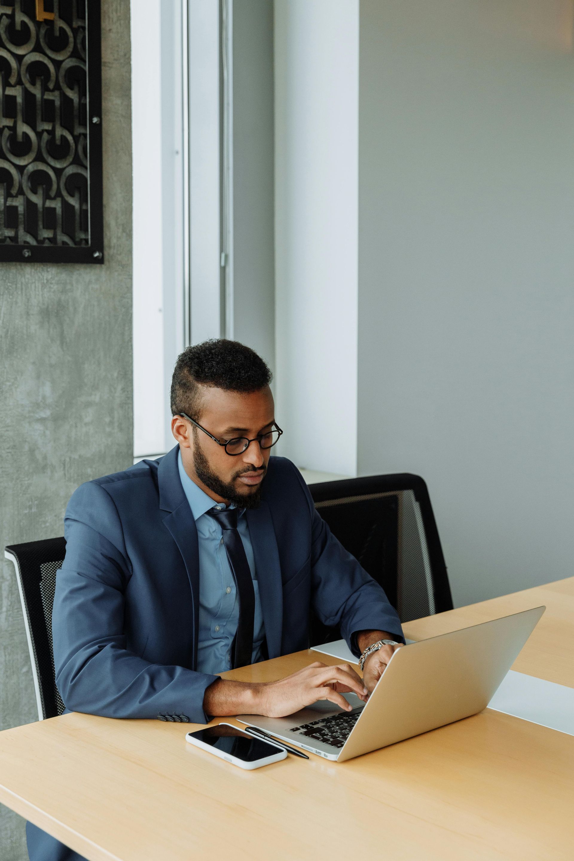 A man with a backpack is standing next to a lake in the woods.