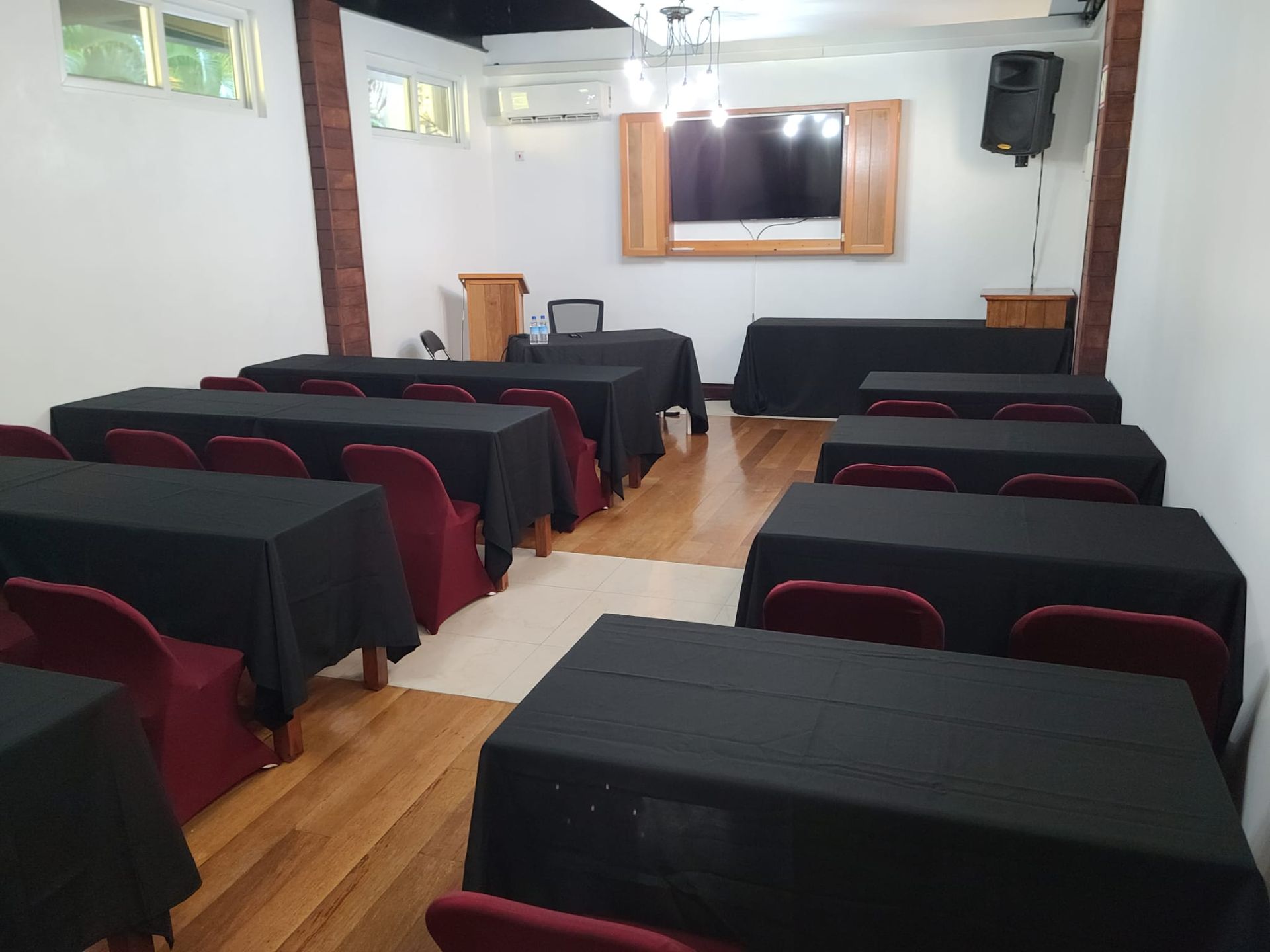 Rows of black tables and red chairs in a room