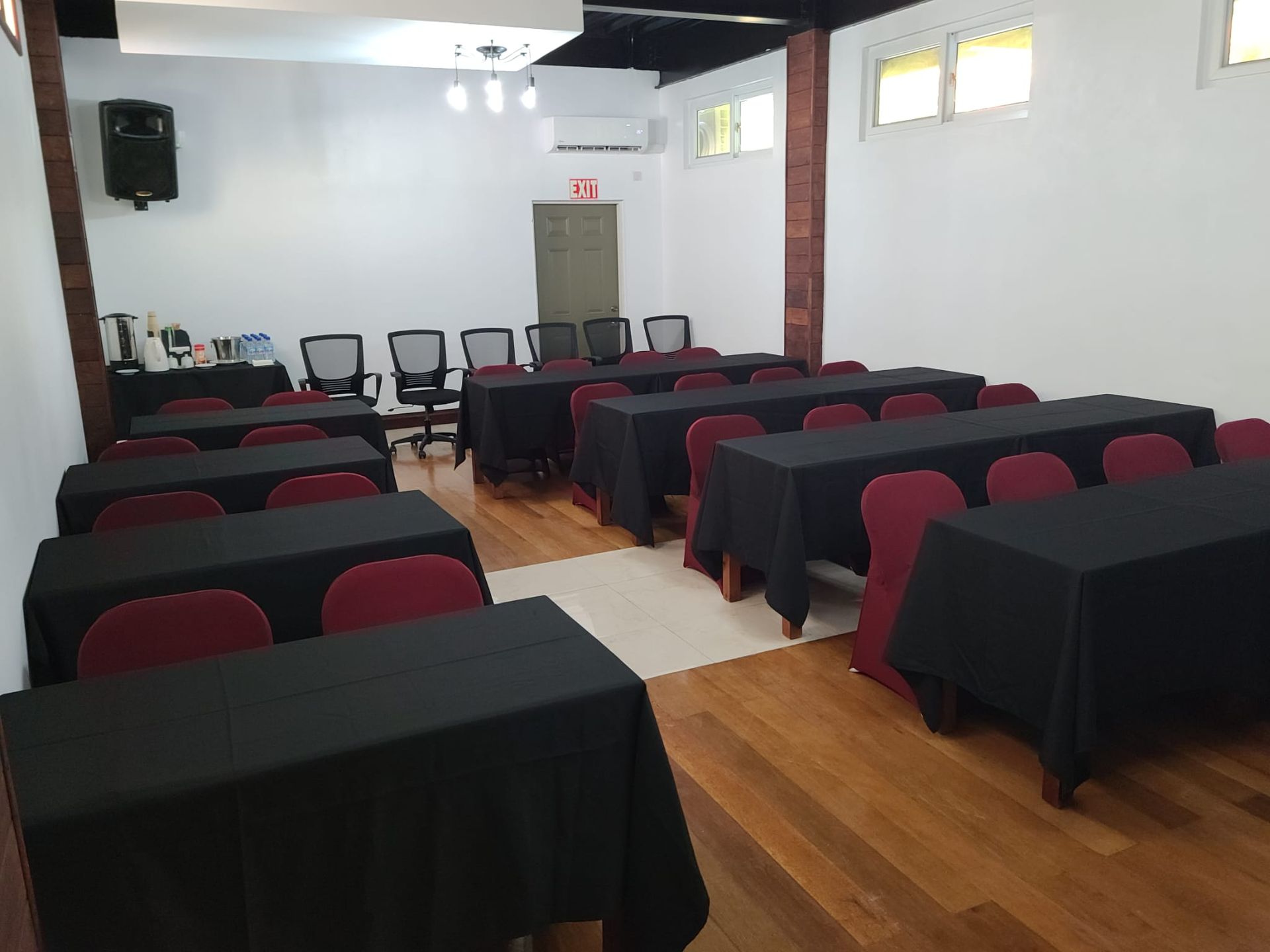 A room with rows of tables and chairs with black covers
