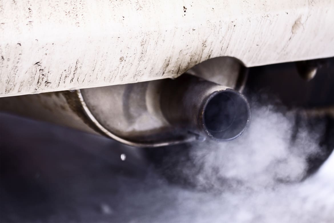 Smoke is coming out of the exhaust pipe of a car.