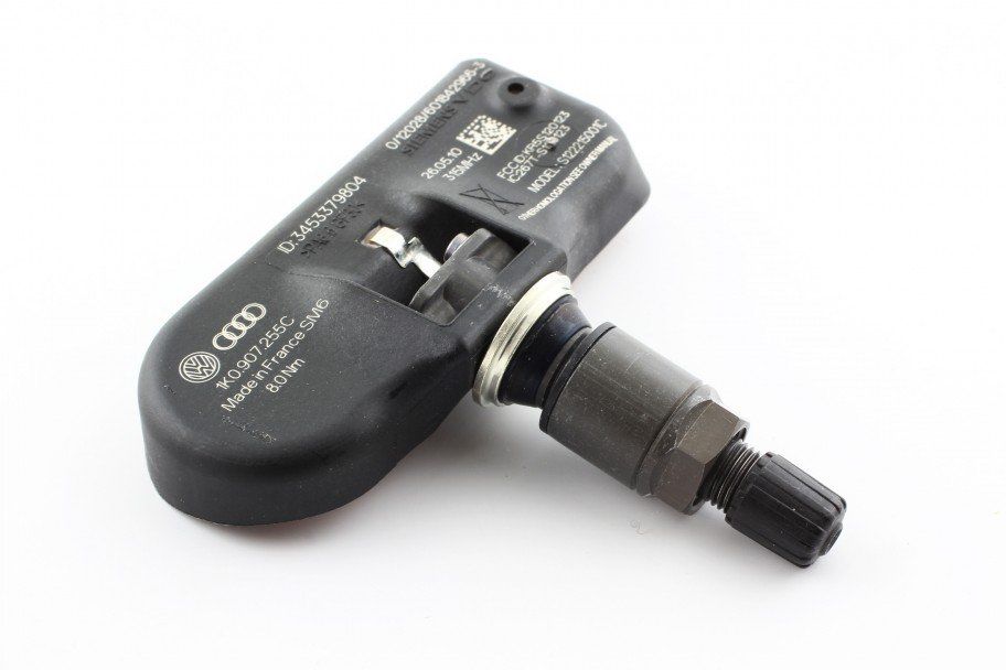 A close up of an audi tire pressure sensor on a white surface
