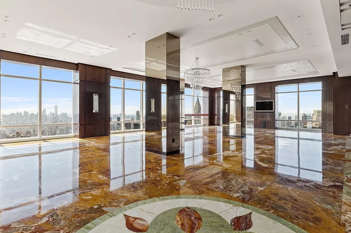 A large room with a lot of windows and a marble floor.