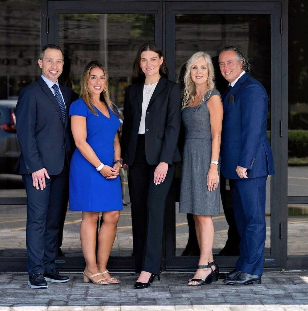 A group of people are posing for a picture in front of a building.