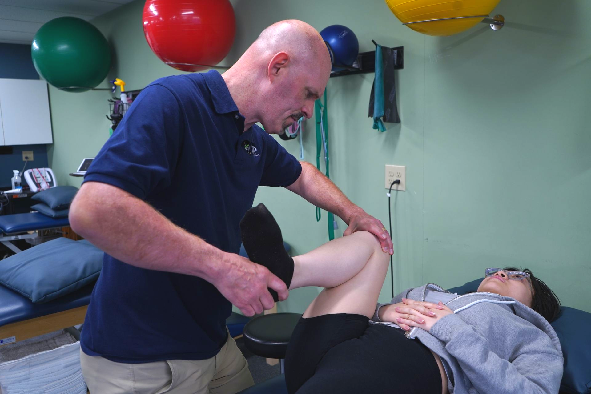 Therapist performing leg rehabilitation exercise at AMP Physical Therapy Edison NJ.