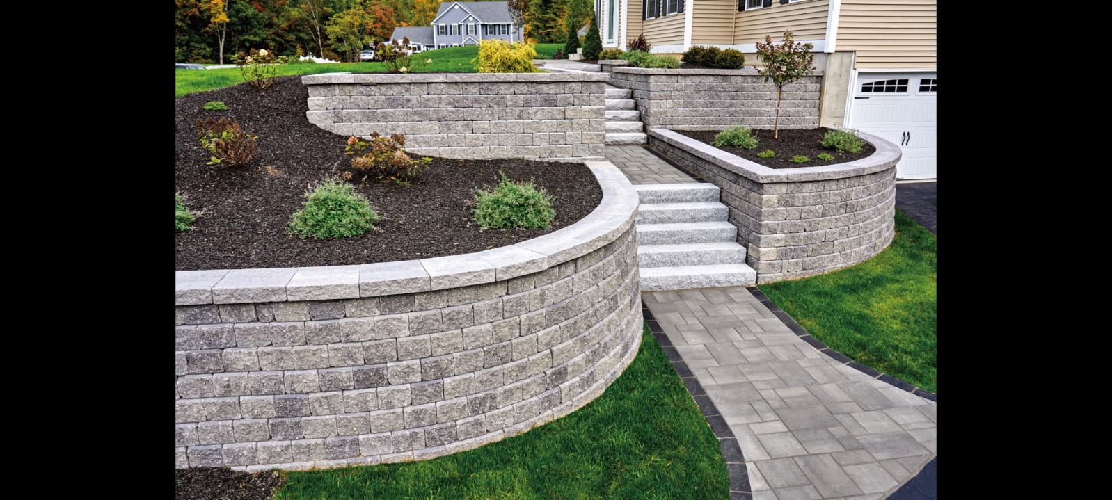 A stone wall with stairs leading up to a house.