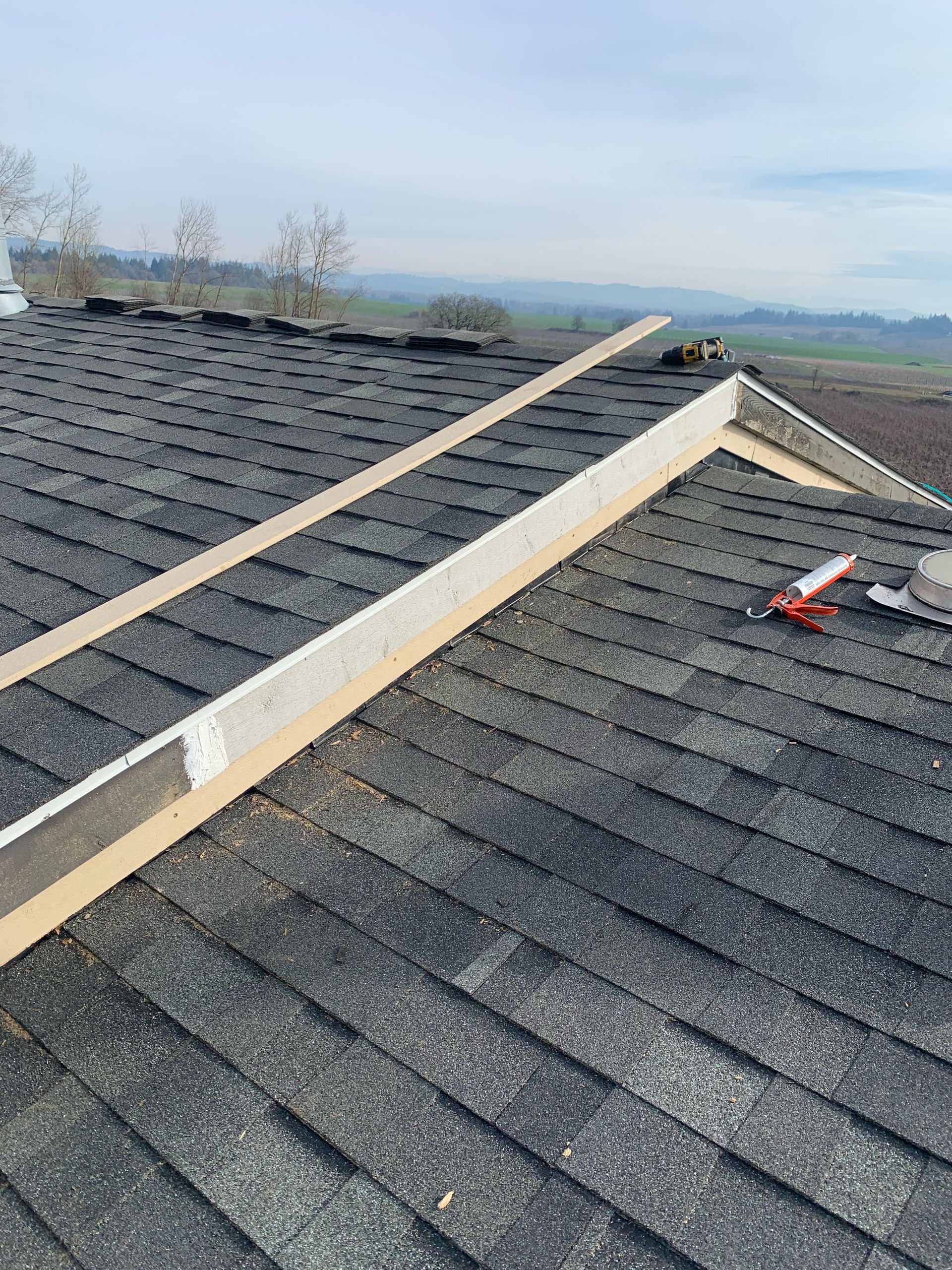 A close up of a roof with shingles being installed.