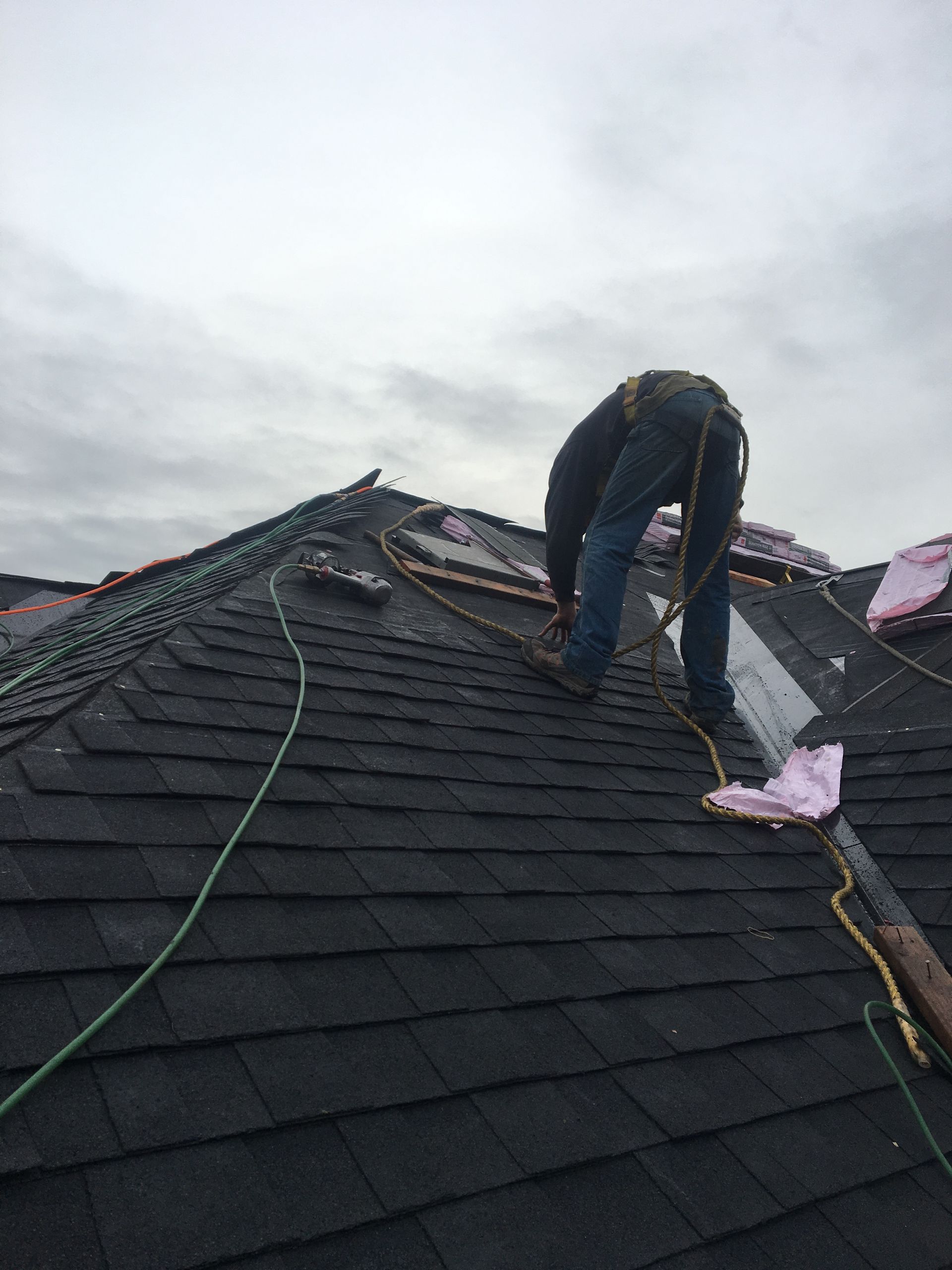A man is working on the roof of a house.