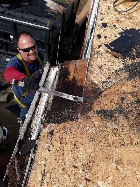 A man is cutting a piece of wood with a saw