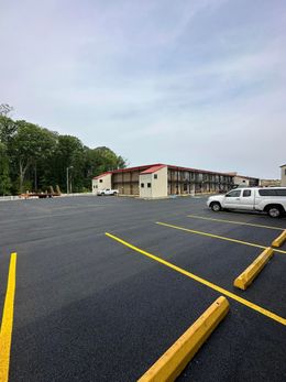 A parking lot with cars parked in front of a hotel.