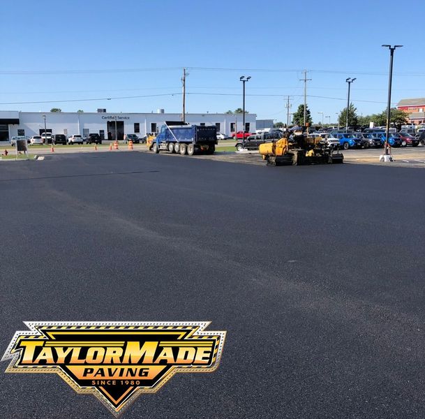 A machine is spraying asphalt on the side of a road