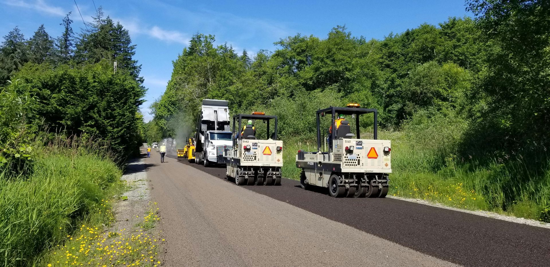 A couple of trucks are driving down a road.