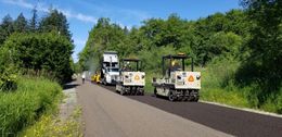 A couple of trucks are driving down a road.