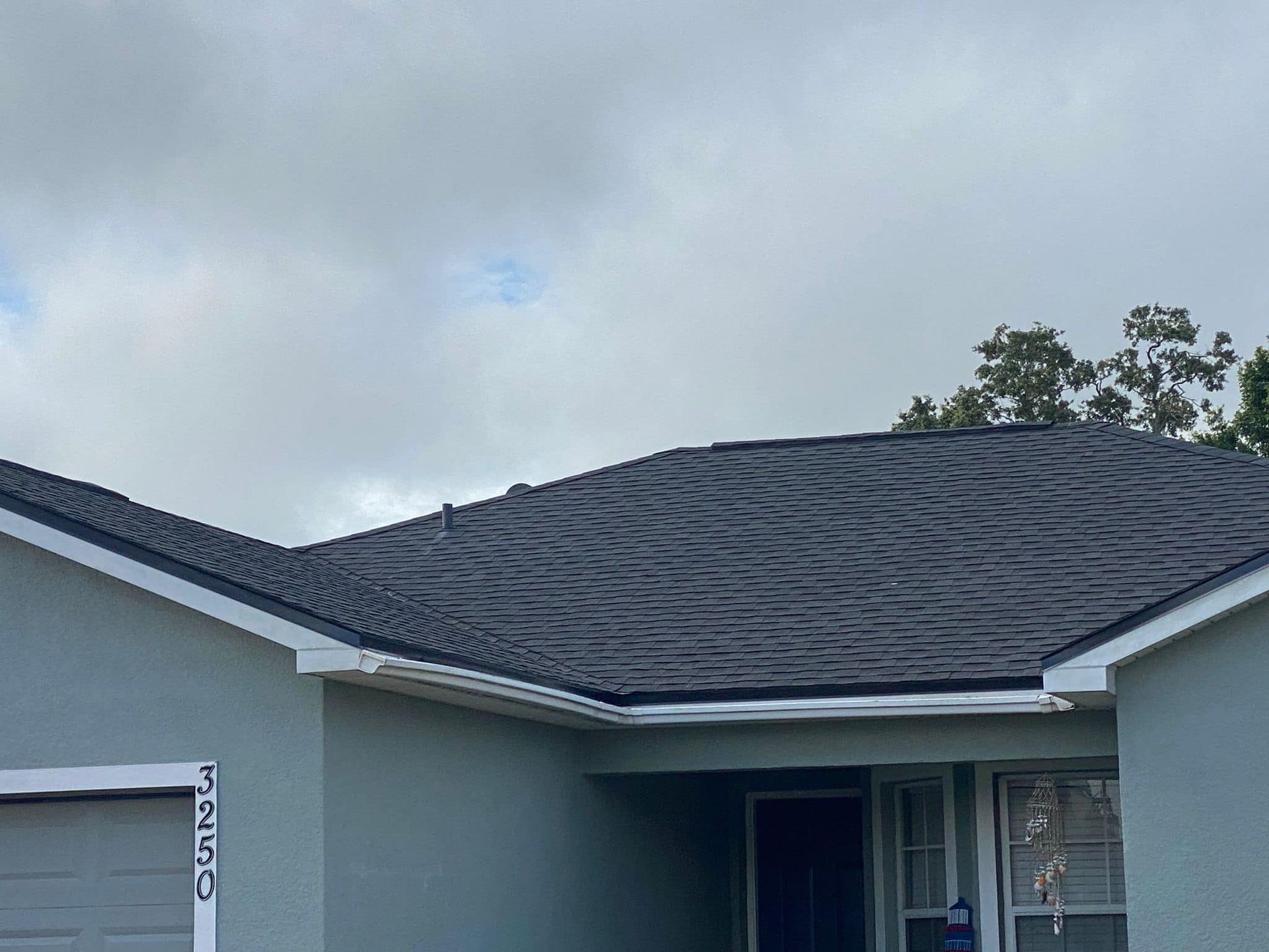 A house with a black roof and a white garage door.