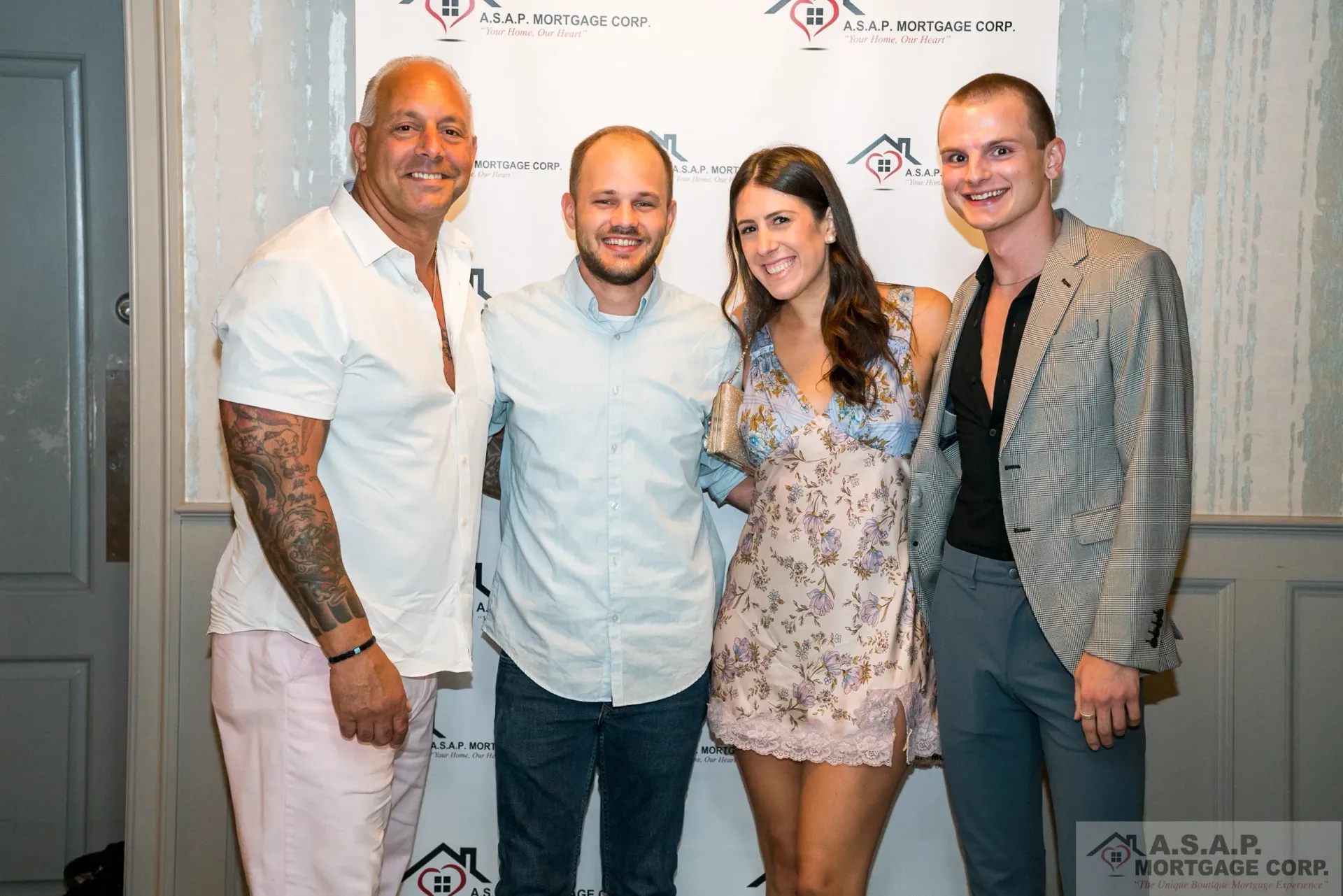 A group of people are posing for a picture in front of a wall.