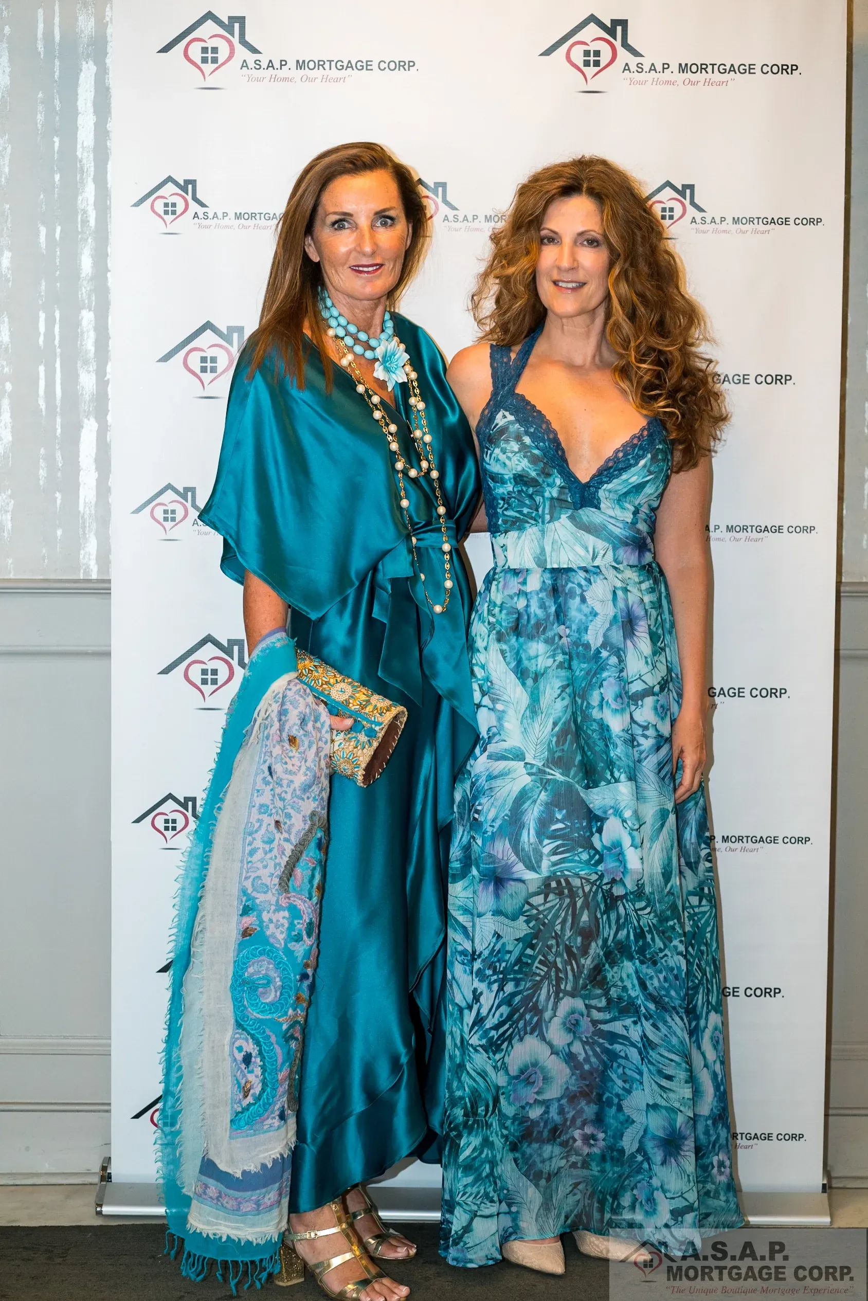 Two women in blue dresses are posing for a picture.