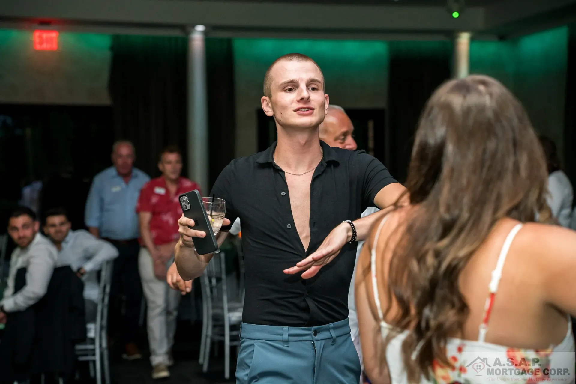 A man is holding a glass of wine while dancing with a woman.