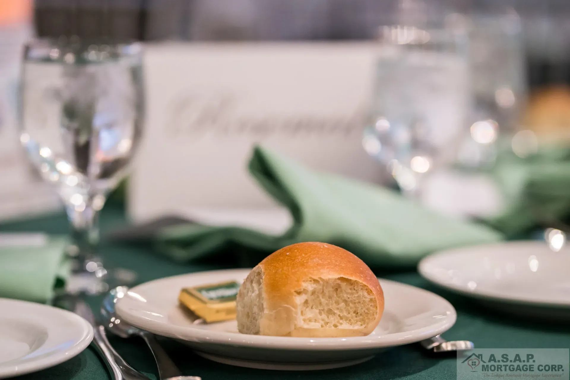 A roll of bread is on a white plate on a table.