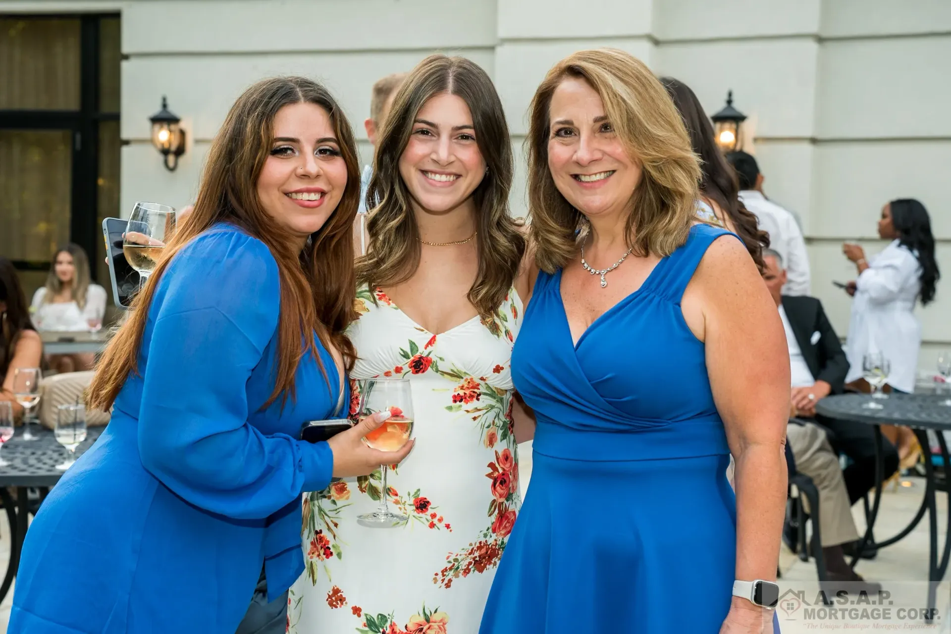 Three women in blue dresses are posing for a picture.